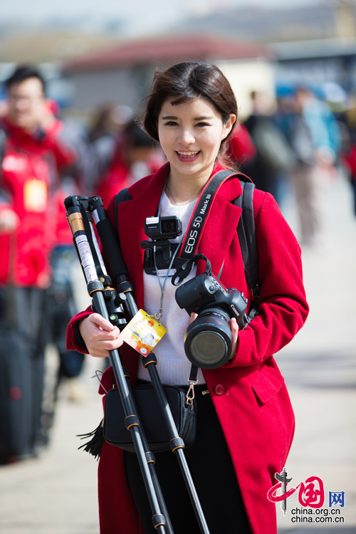 2016年兩會，人民大會大堂前，一位笑容燦爛的紅衣女記者正步入大會堂。中國網(wǎng) 鄭亮 攝