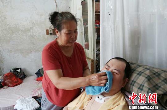 每次喂完食物后，梁青蘭都要仔細(xì)地幫兒子清理干凈?！∩忻鱾b 攝