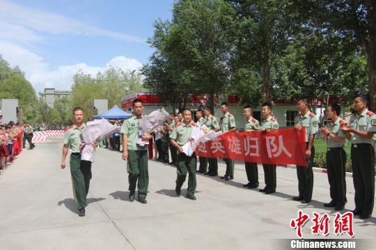 部隊官兵們迎接出院歸來的李運飛(中)和其他消防戰(zhàn)士?！⊥粲?攝
