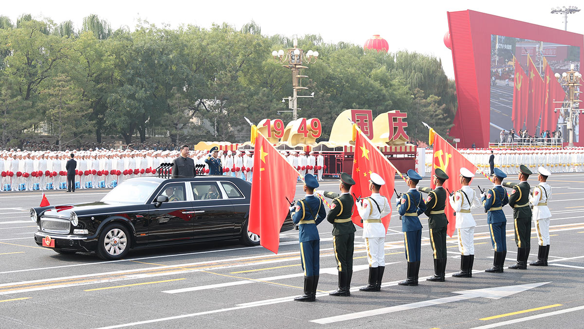 習近平驅(qū)車行進至黨旗、國旗、軍旗前，向旗幟行注目禮