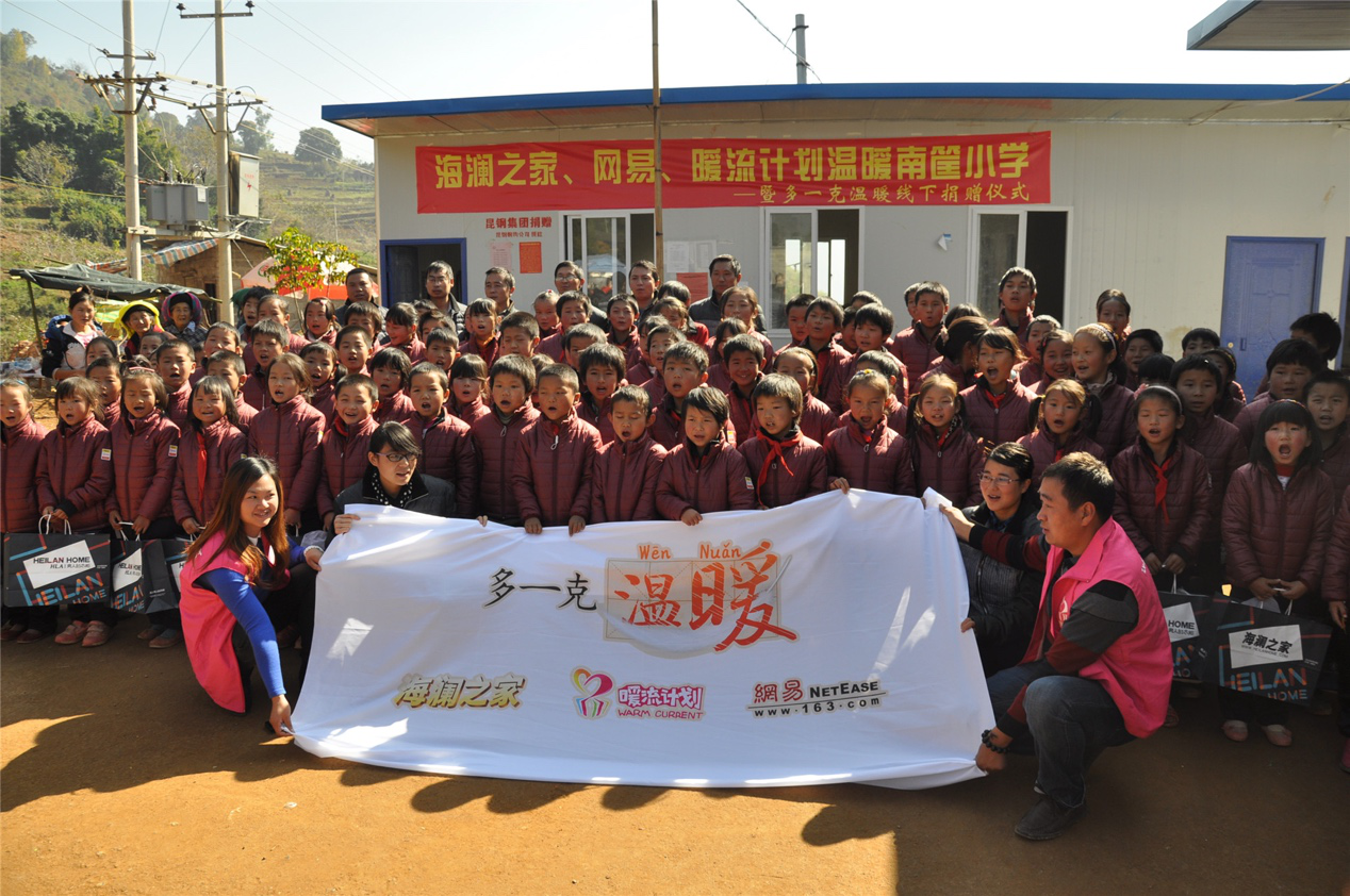 2014年11月20日，“多一克溫暖”公益團(tuán)隊來到8.3大地震的重災(zāi)區(qū)——云南省昭通市魯?shù)榭h的南筐小學(xué)。越過崎嶇山路，將一批又一批暖心羽絨服送到了師生們的手中，也將社會的關(guān)懷和愛意傳遞給了這些可愛的人。