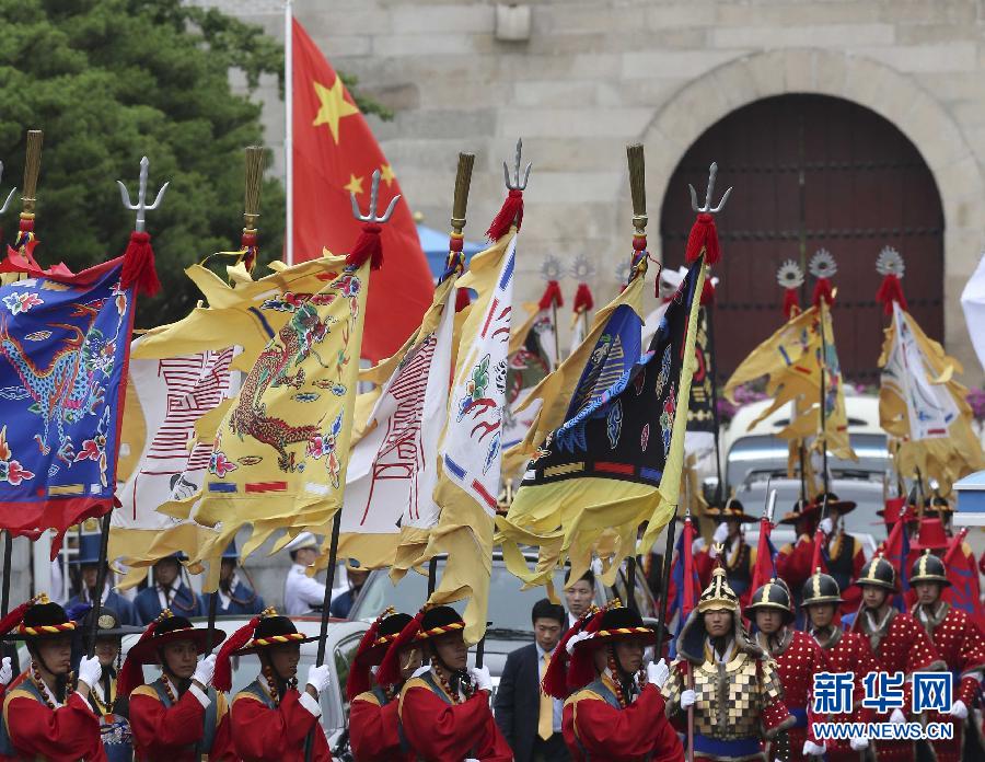 7月3日，韓國總統(tǒng)樸槿惠在青瓦臺總統(tǒng)府舉行隆重儀式，歡迎中國國家主席習(xí)近平對韓國進(jìn)行國事訪問。這是習(xí)近平的車隊(duì)在身著民族服裝的韓國禮儀隊(duì)伍引導(dǎo)下駛?cè)肭嗤吲_。新華社記者丁林?jǐn)z  