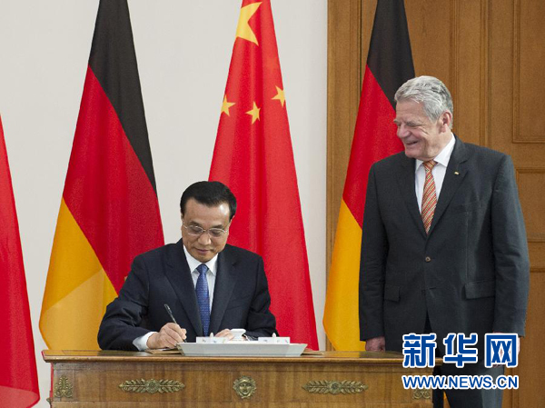 10月10日，國務(wù)院總理李克強在柏林會見德國總統(tǒng)高克。這是李克強總理在高克總統(tǒng)的陪同下在貴賓簿上簽字。 新華社記者 王曄 攝 